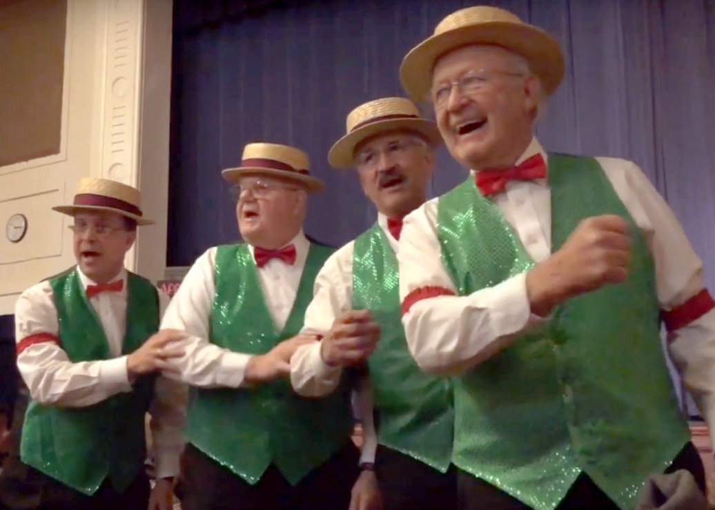 MC-GreenVests Mint Condition singing, wearing vests, bow ties, and straw hats.